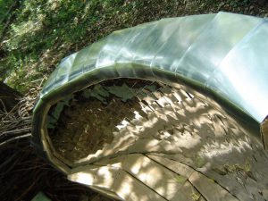 metal-clad curved back to a portion of a bench